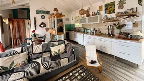 A spacious living area with a sofa, a coffee table, and a chair. There is a kitchen area with cabinets and a microwave. - Villa Kaz à Colibri with swimming pool for a relaxing break with family or friends (Unknown)