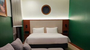 Una habitación de hotel con una cama grande, un sofá y una pequeña mesa redonda.