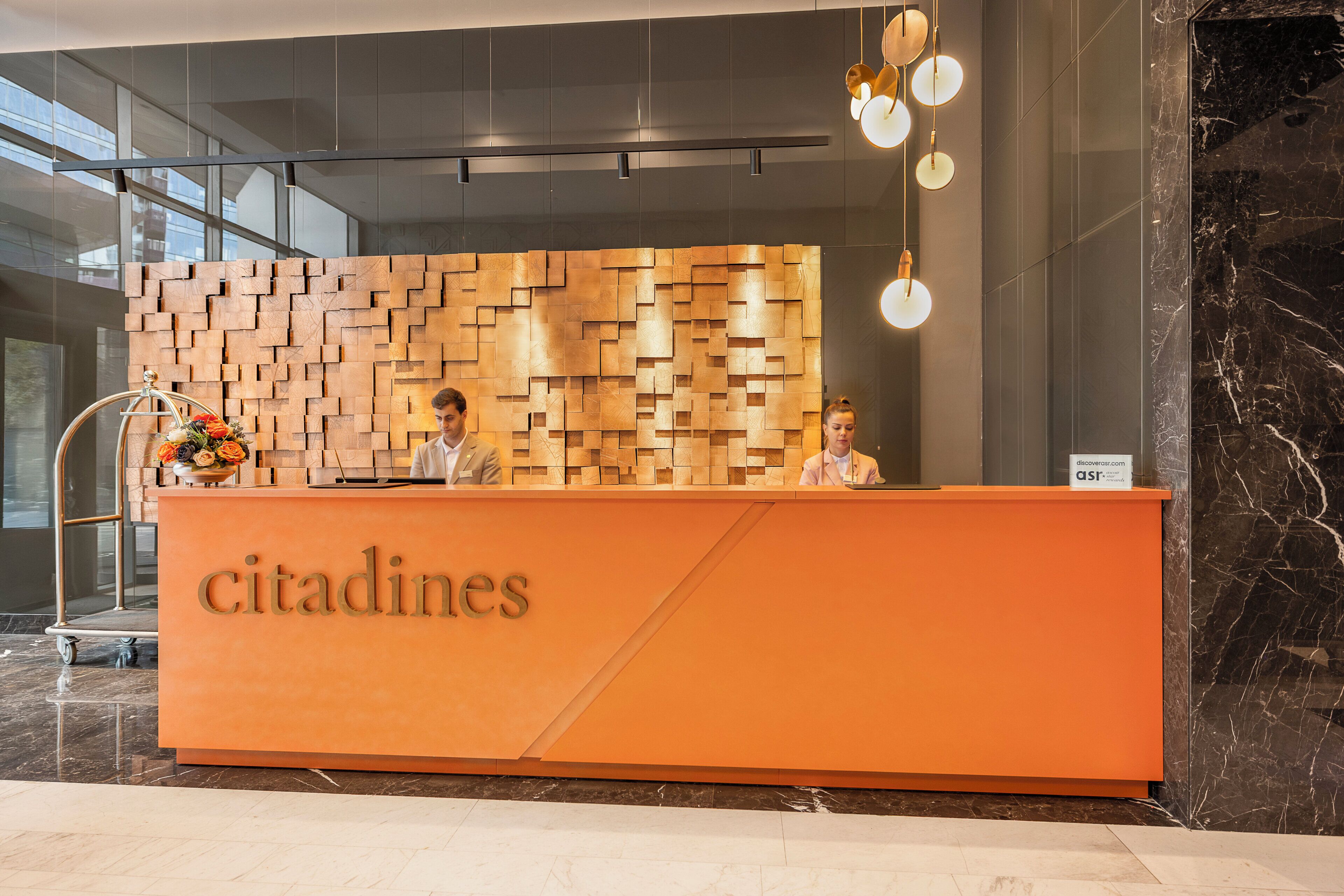 A reception desk with a wooden panel design and the word "citadines" on it.