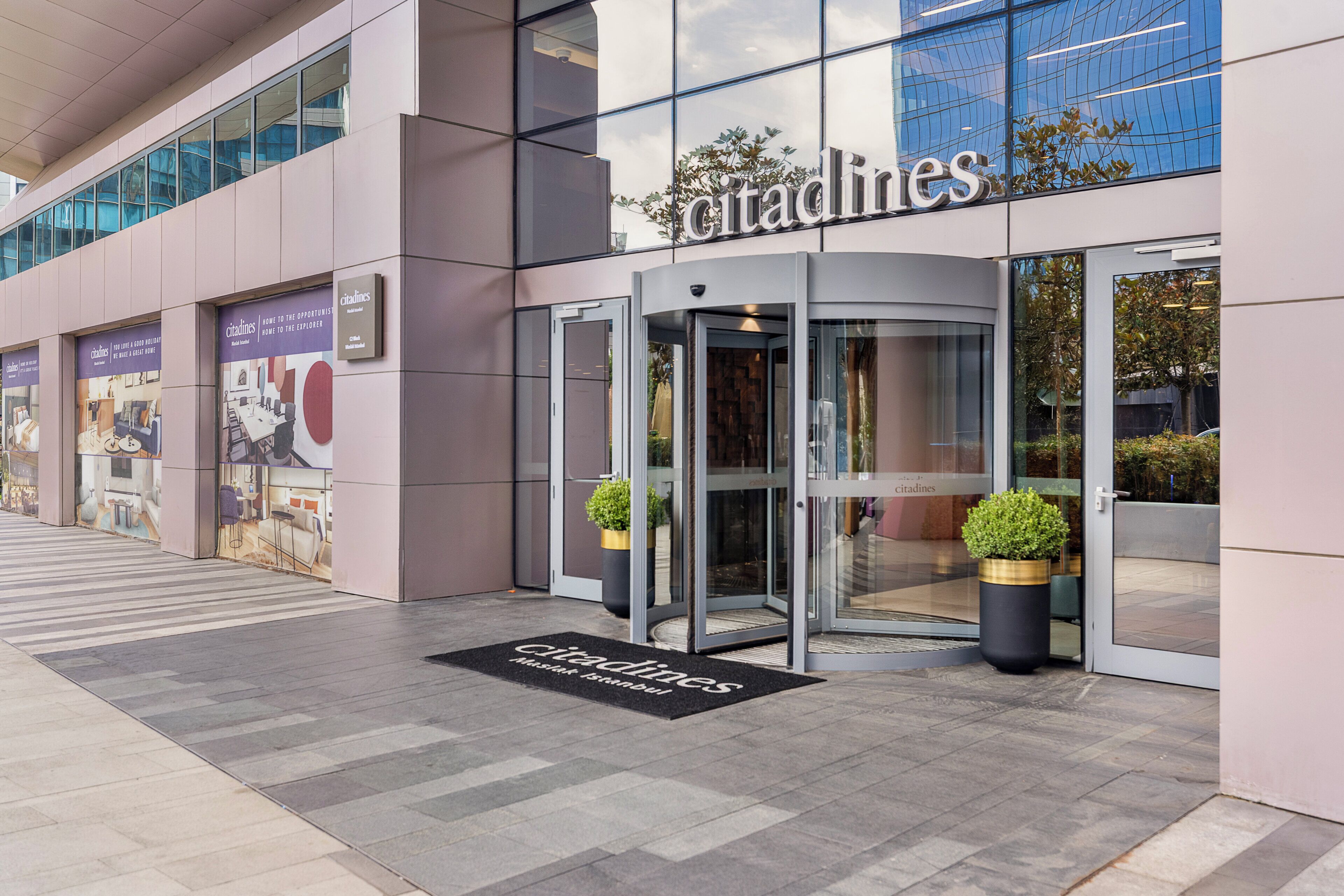 A modern building with a glass facade and a revolving door entrance.