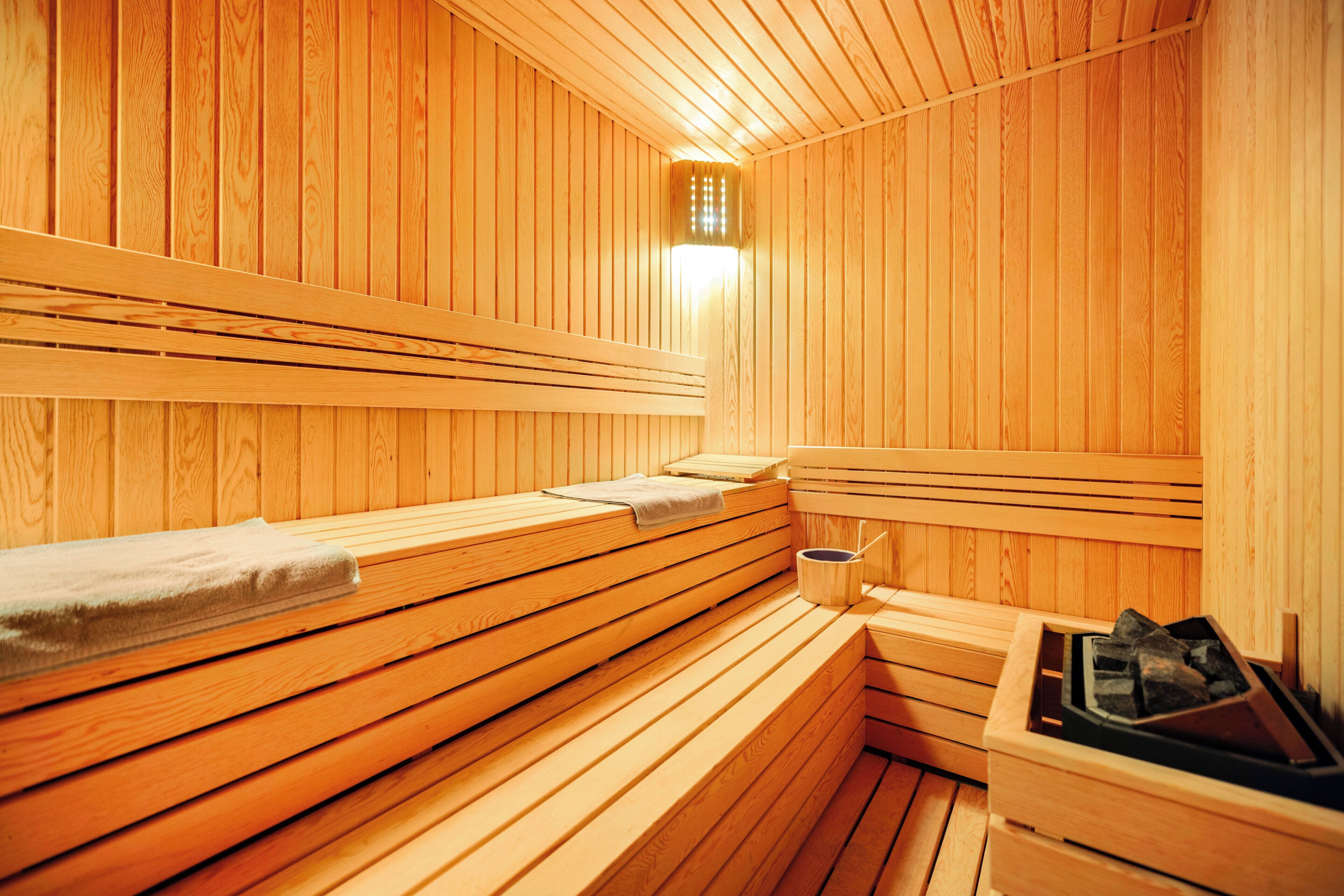 Eine Sauna mit Holzbänken und einer Bank mit Handtuch.