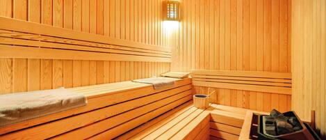 Eine Sauna mit Holzbänken und einer Bank mit Handtuch.