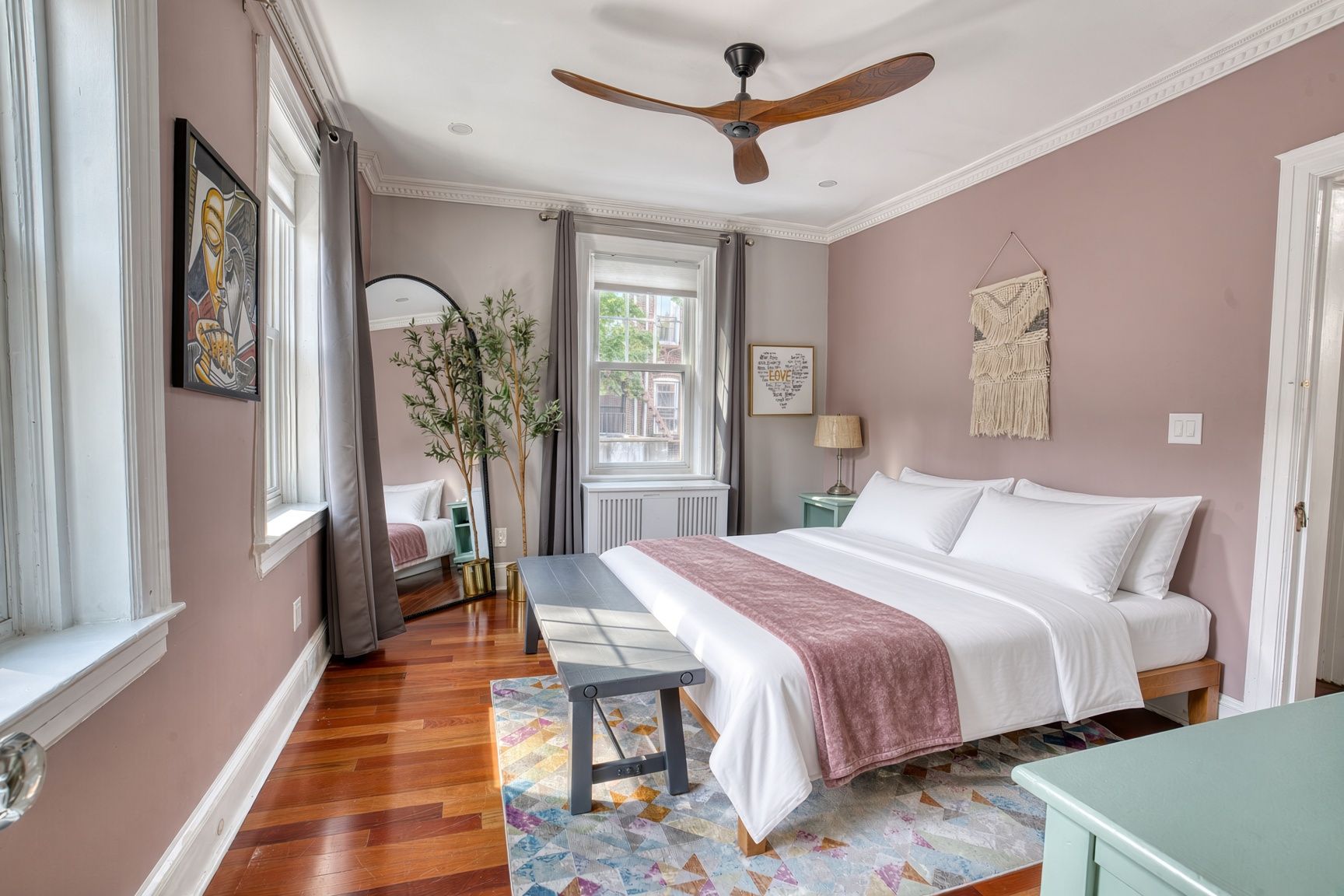 A bedroom with a bed, bedside table, and a ceiling fan.