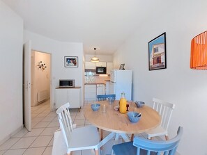 A compact kitchen with white cabinets, a microwave, and a refrigerator. - Parc de Pontaillac by Interhome (Vaux Sur Mer)