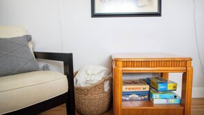 A living room with a sofa, a small wooden side table, and a woven basket.