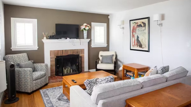 A living room with a fireplace, a sofa, a coffee table, and a TV.