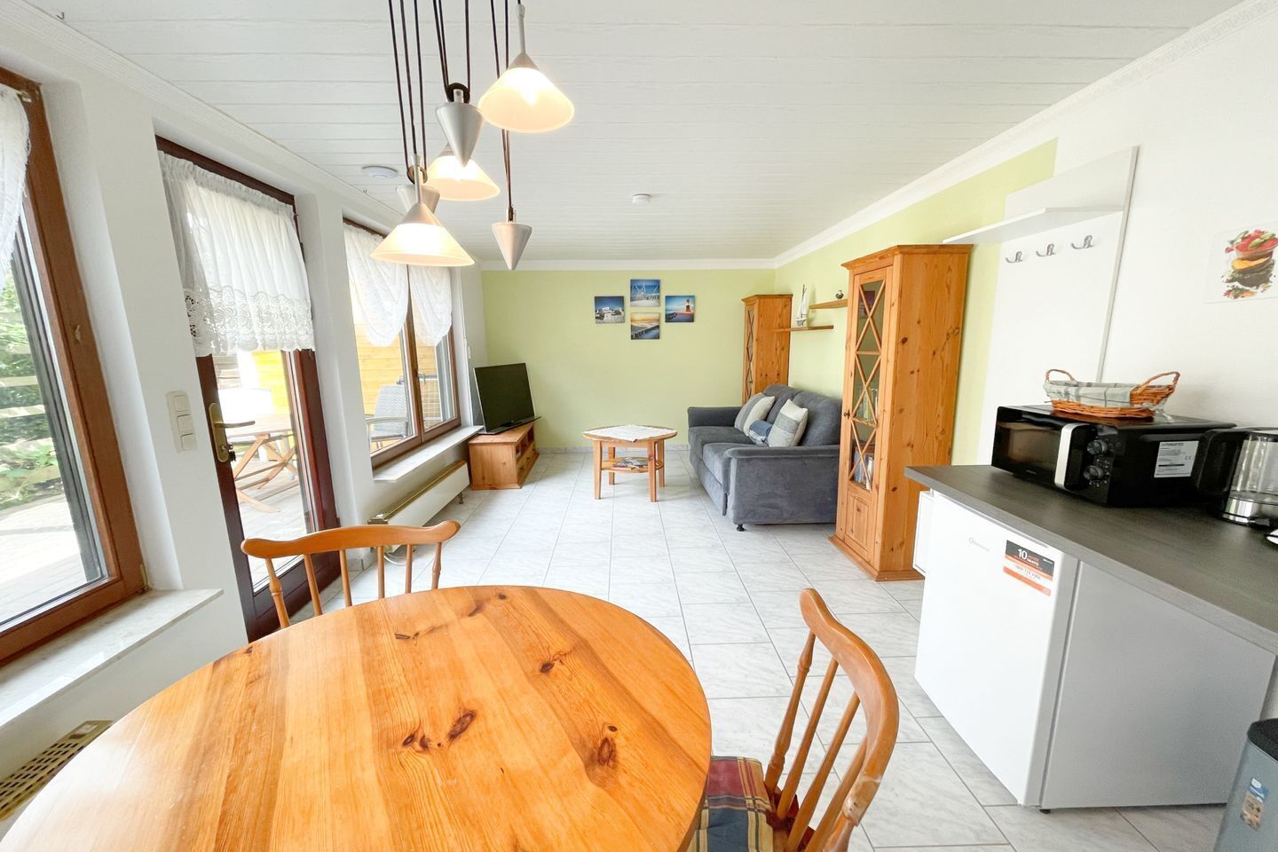 Un espacio habitable compacto con comedor, kitchenette y zona de estar.