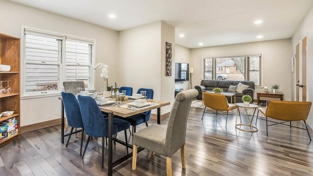 A spacious living area with a dining table, blue chairs, a grey armchair, and a sofa. - Beautiful Get-a-way in the Heart of Sioux Falls (Sioux Falls)