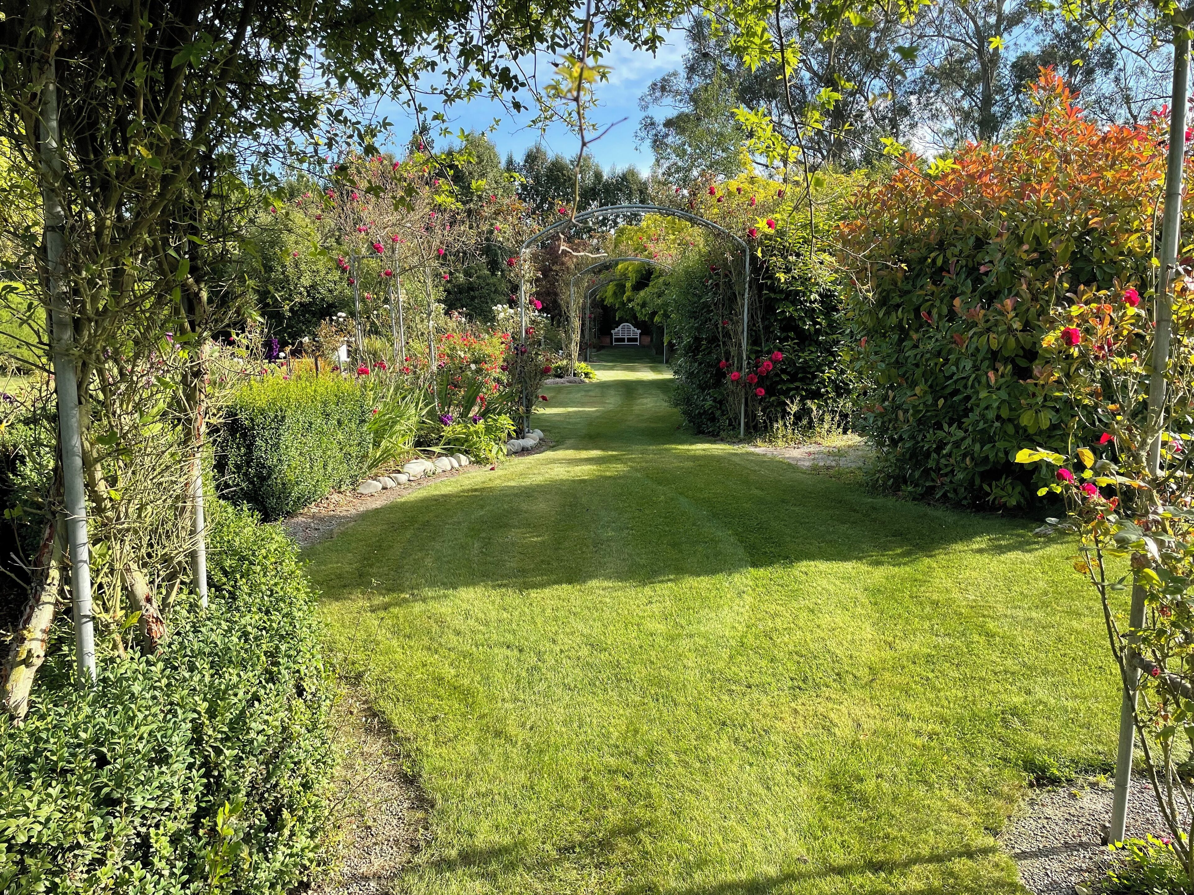 A well-maintained garden with a clear pathway leading to a gazebo.