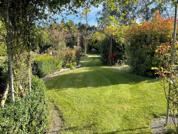 A well-maintained garden with a clear pathway leading to a gazebo.