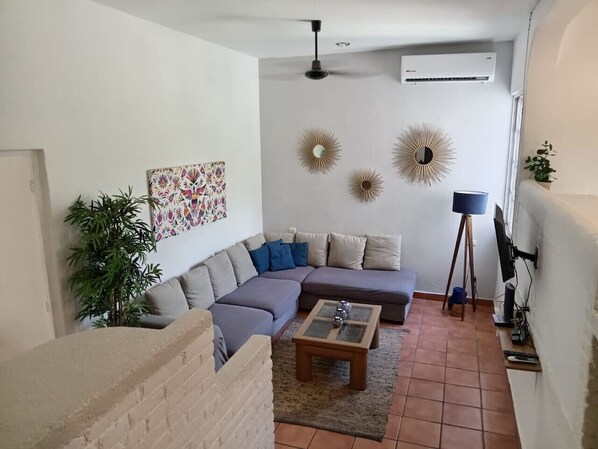 Ein Wohnzimmer mit einem Ecksofa, einem Couchtisch und Wandbildern.