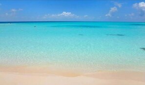 Ein Strand mit klarem türkisblauem Wasser und einem Sandstrand.