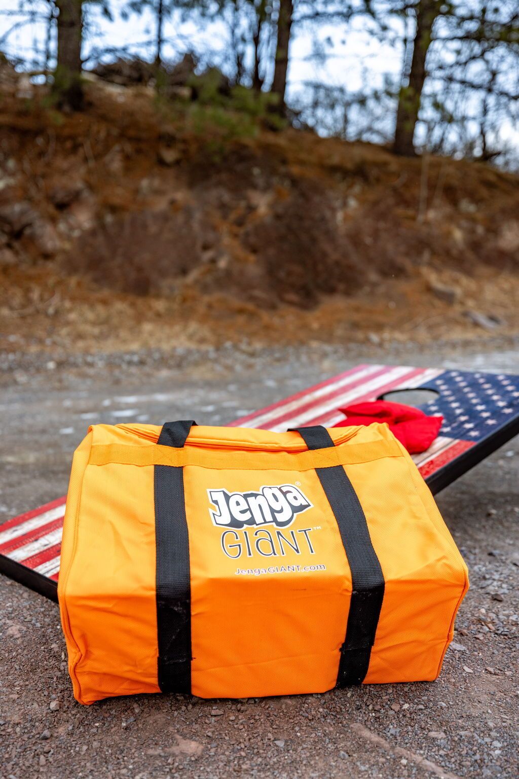 Un sac de jeu Jenga géant posé sur une table, avec un drapeau américain à proximité.