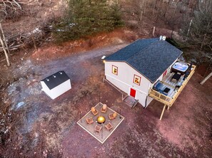 Eine Vogelperspektive zeigt eine Hütte mit einer Terrasse, einem Whirlpool und einer Feuerstelle.