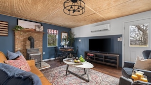 Un salon chaleureux avec une cheminée, un téléviseur et des fauteuils confortables.