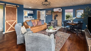Un salon avec un plafond en bois, un canapé, une table basse et une cheminée.