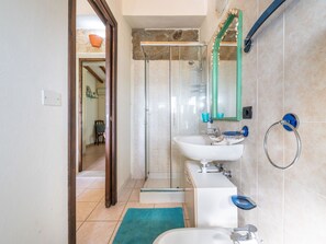 A bathroom with a shower, sink, and toilet.