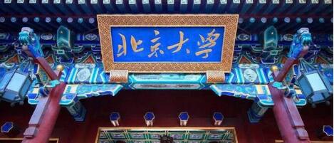 A traditional Chinese building with ornate architecture and a sign reading "北京大学" (Peking University).