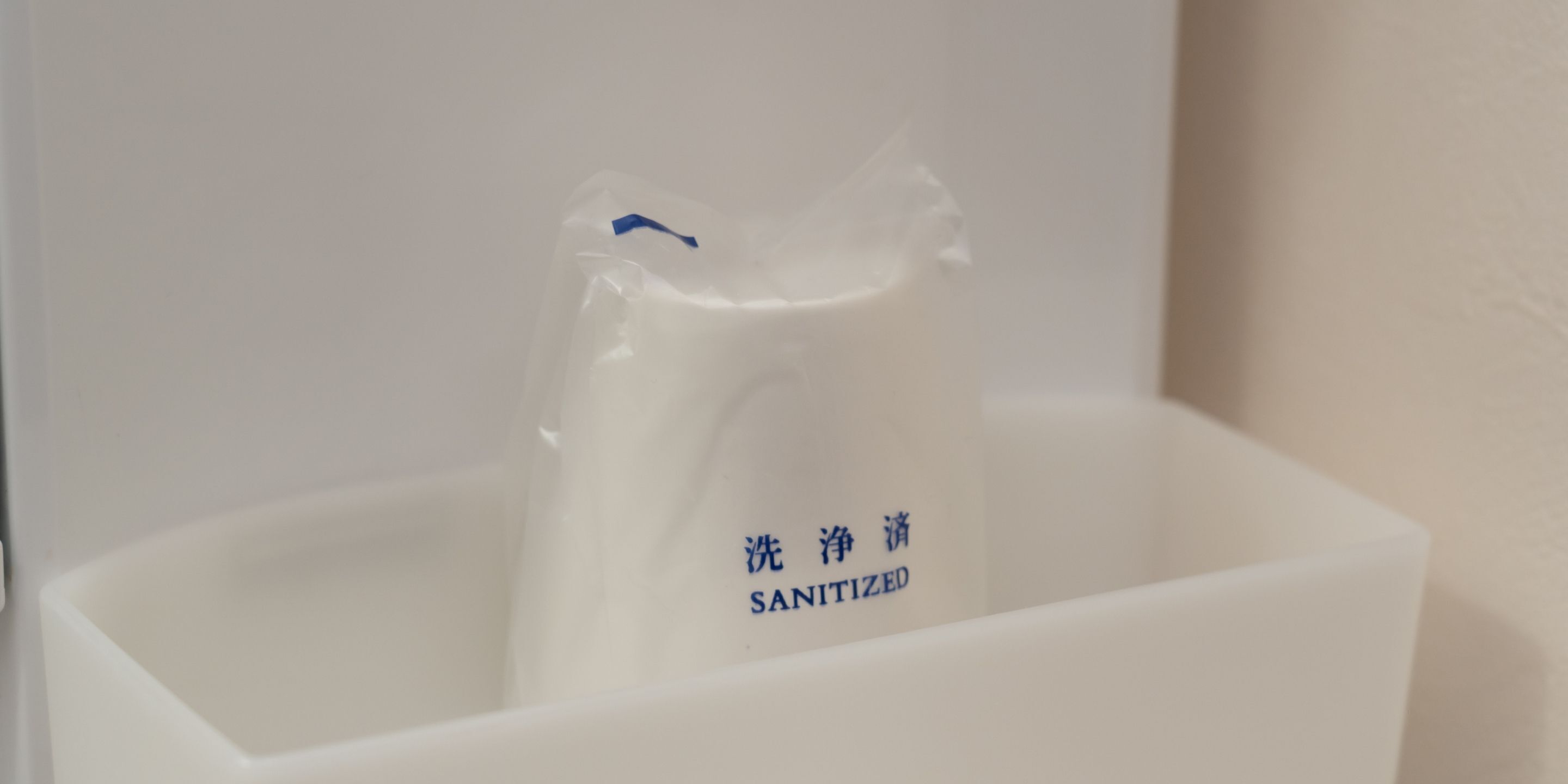 A white container with a blue label that reads "SANITIZED".