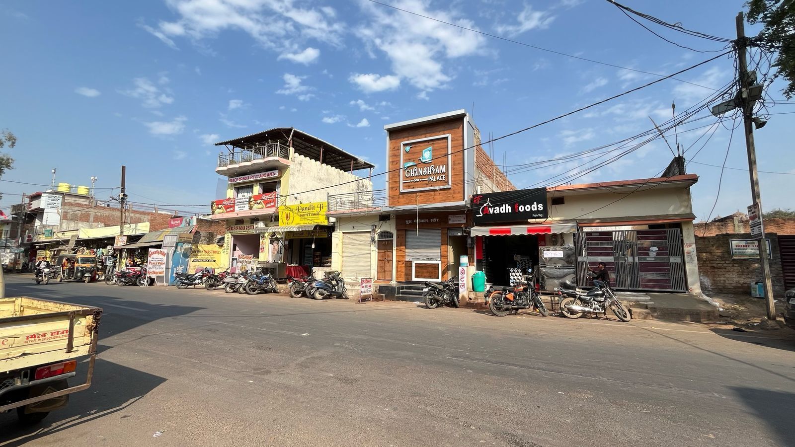 A street view with various shops, including a restaurant and a palace.
