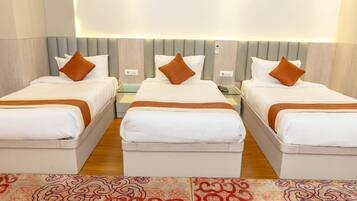 Habitación triple Deluxe, para no fumadores, vista a la ciudad | Muebles diferentes, escritorio y espacio para trabajar con laptop