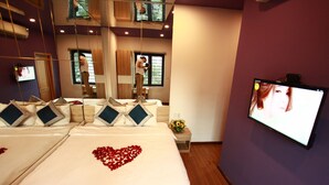 A hotel room with a large bed, a TV, and a mirror. - Mata Love hotel (Da Nang)