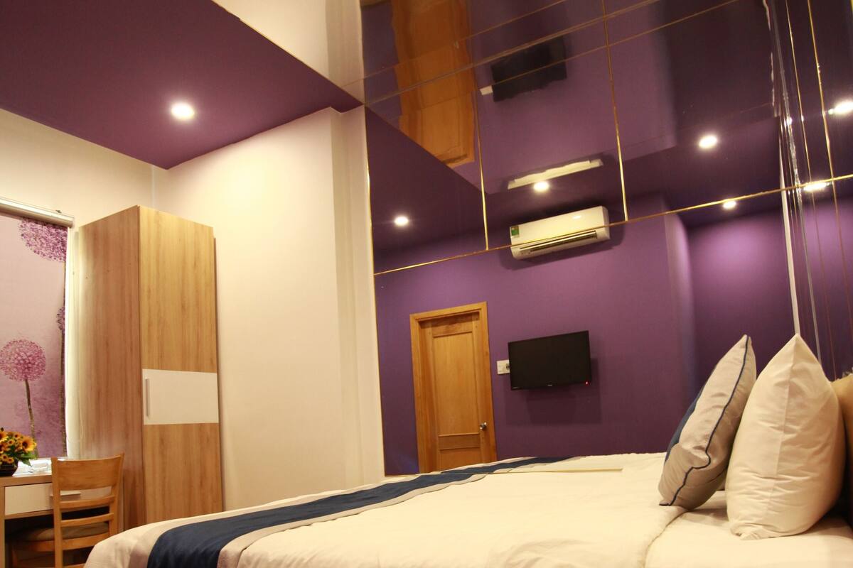 Un dormitorio moderno con una cama de madera, un escritorio y una silla.
