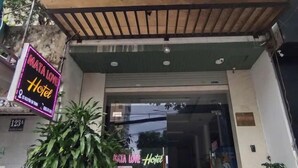 A building with a sign for 'MATA LOVE Hotel' and a motorcycle parked in front. - Mata Love hotel (Da Nang)