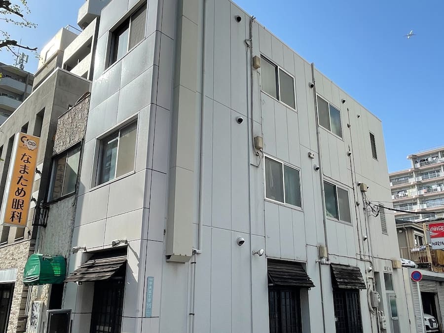 Un bâtiment moderne à la façade plate, doté de nombreuses fenêtres et d’une enseigne indiquant qu’il s’agit d’un commerce.