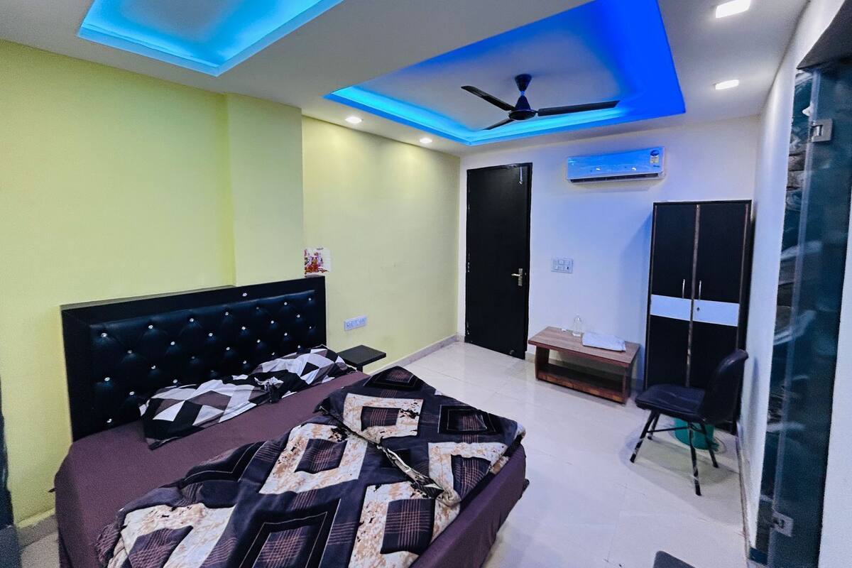 Een slaapkamer met een bed, een plafondventilator, een airconditioning en een kledingkast.