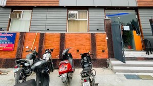 Un edificio de varios pisos con fachada moderna, destacando amplias ventanas y un letrero para un hotel residencial.