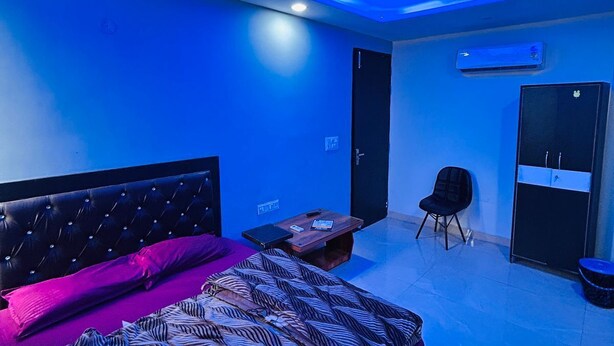 Un dormitorio con cama, una silla, un escritorio y un armario.