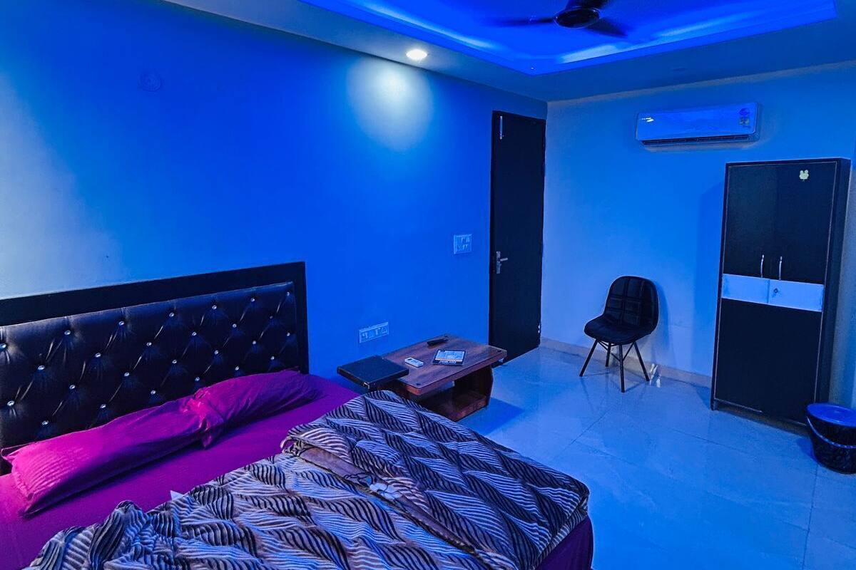 Een slaapkamer met een bed, een stoel, een bureau en een kledingkast.