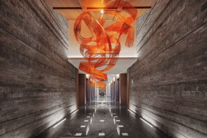 A corridor with brick walls, a polished floor, and a central light fixture. - UrCove By Hyatt Nanjing Zhongshanling Resort (Nanjing)