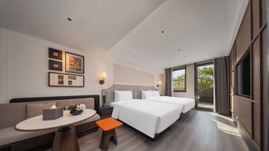 A modern hotel room with a sofa, a small table, a nightstand, a bed, and a TV. - UrCove By Hyatt Nanjing Zhongshanling Resort (Nanjing)