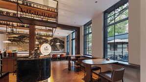 A modern bar with a marble counter, wooden flooring, and a view through large windows. - UrCove By Hyatt Nanjing Zhongshanling Resort (Nanjing)