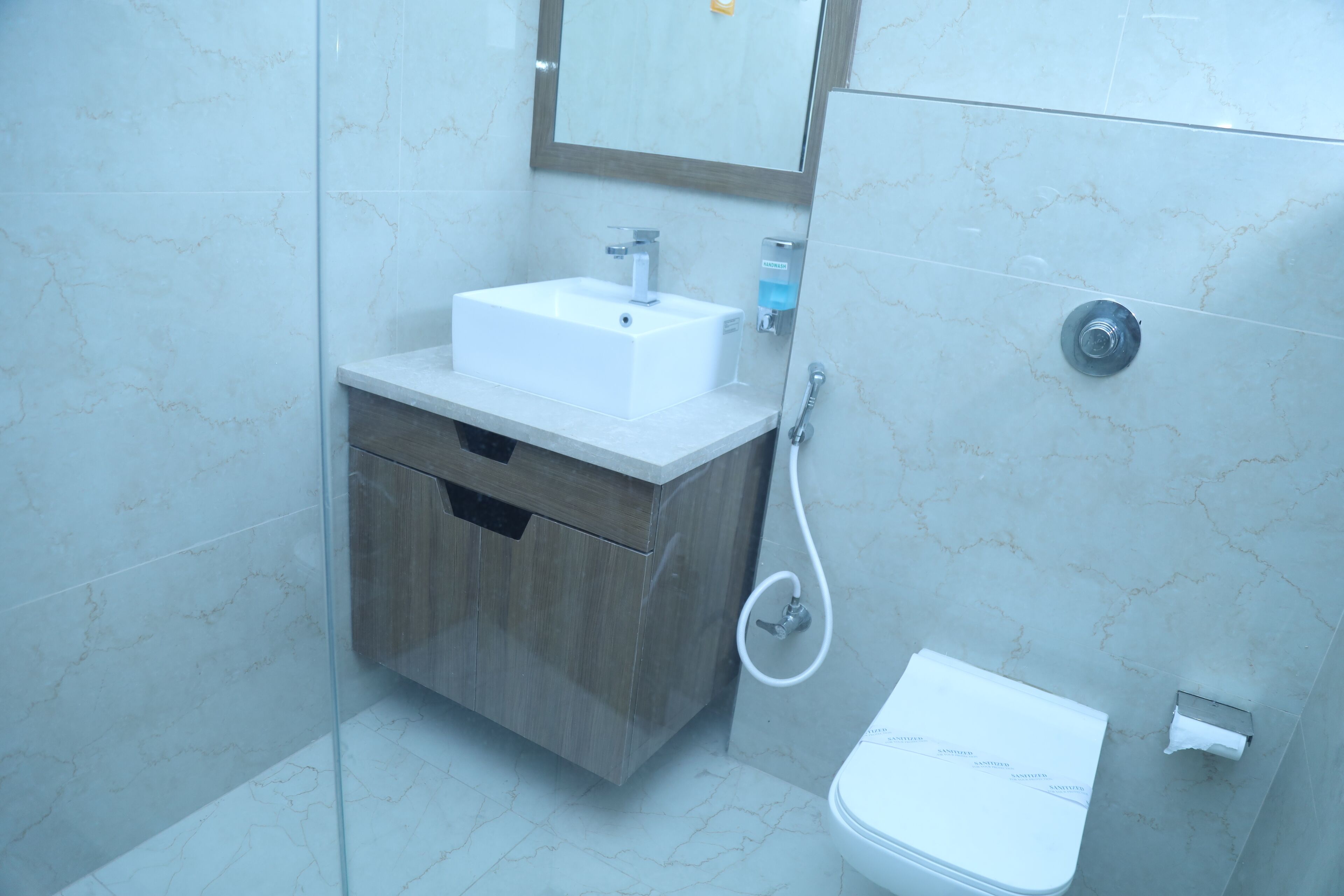Une salle de bain avec un lavabo blanc, un meuble en bois et des toilettes.