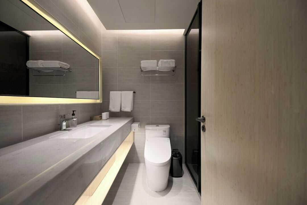 Un baño moderno con un tocador amplio, un inodoro y una zona de ducha.