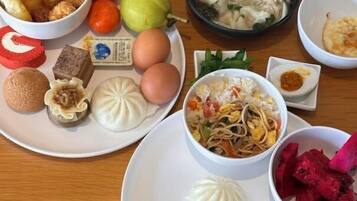 Una mesa con diferentes platos, entre ellos dumplings, fideos y un tazón de sopa.