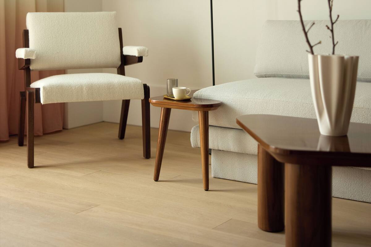 A modern living room with a sofa, a chair, a coffee table, and a framed picture on the wall.