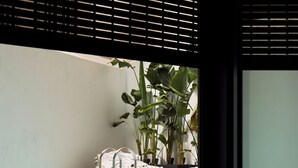 Un espace extérieur moderne, aménagé avec des sièges, une piscine, des coussins à rayures et des plantes en pot.