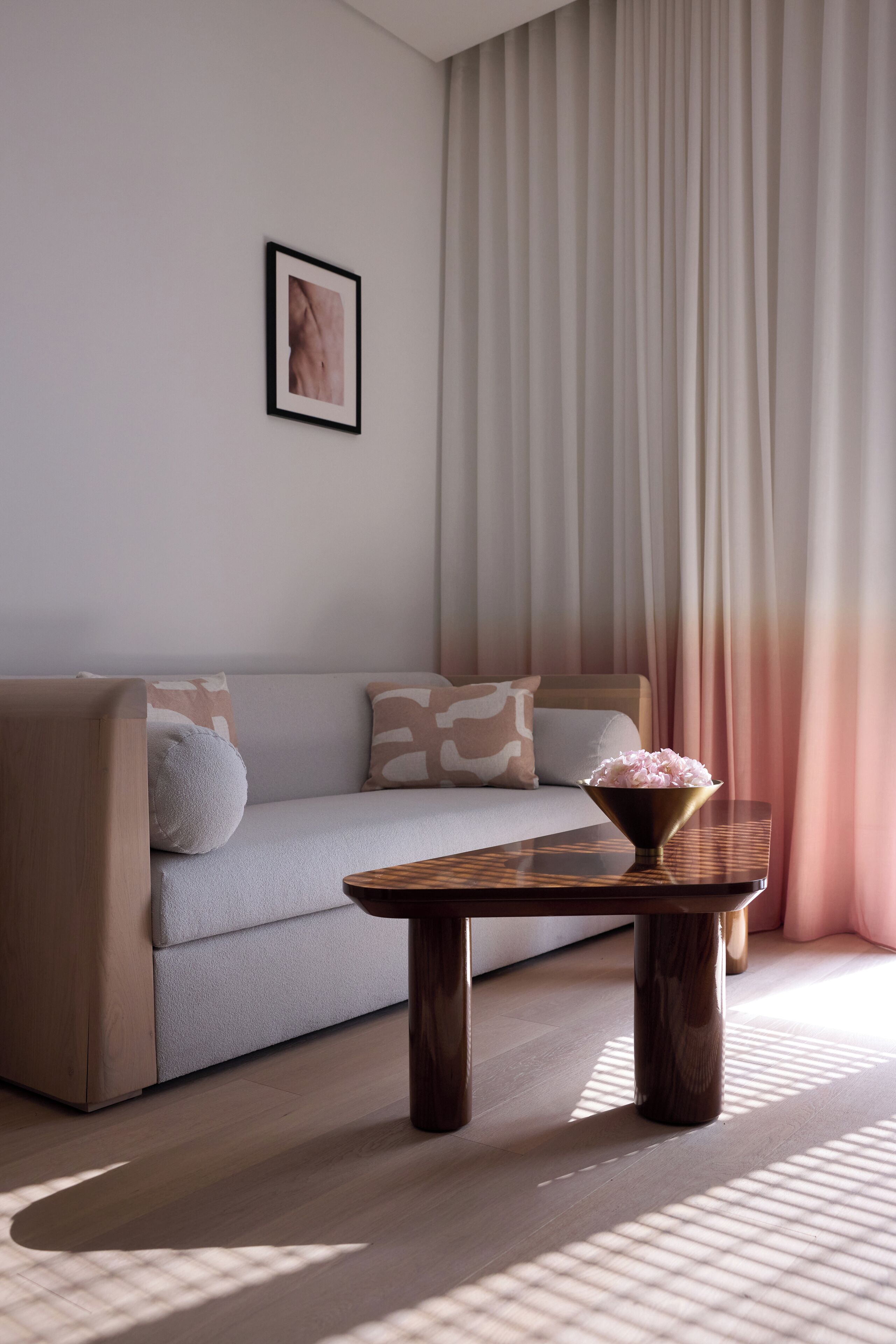 Una sala de estar moderna con un sofá, una mesa de centro y un ventanal con cortinas.