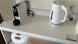 A kitchen counter with a coffee maker, a kettle, and a rice cooker. - Hirafu Cottage (Kutchan)