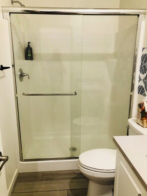 Een douche, handdoeken, zeep, toiletpapier