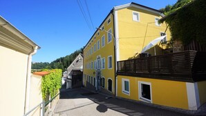 A narrow street with yellow buildings, a visible entrance, and a clear sky. - Vacation apartment with an excellent view (Ach)