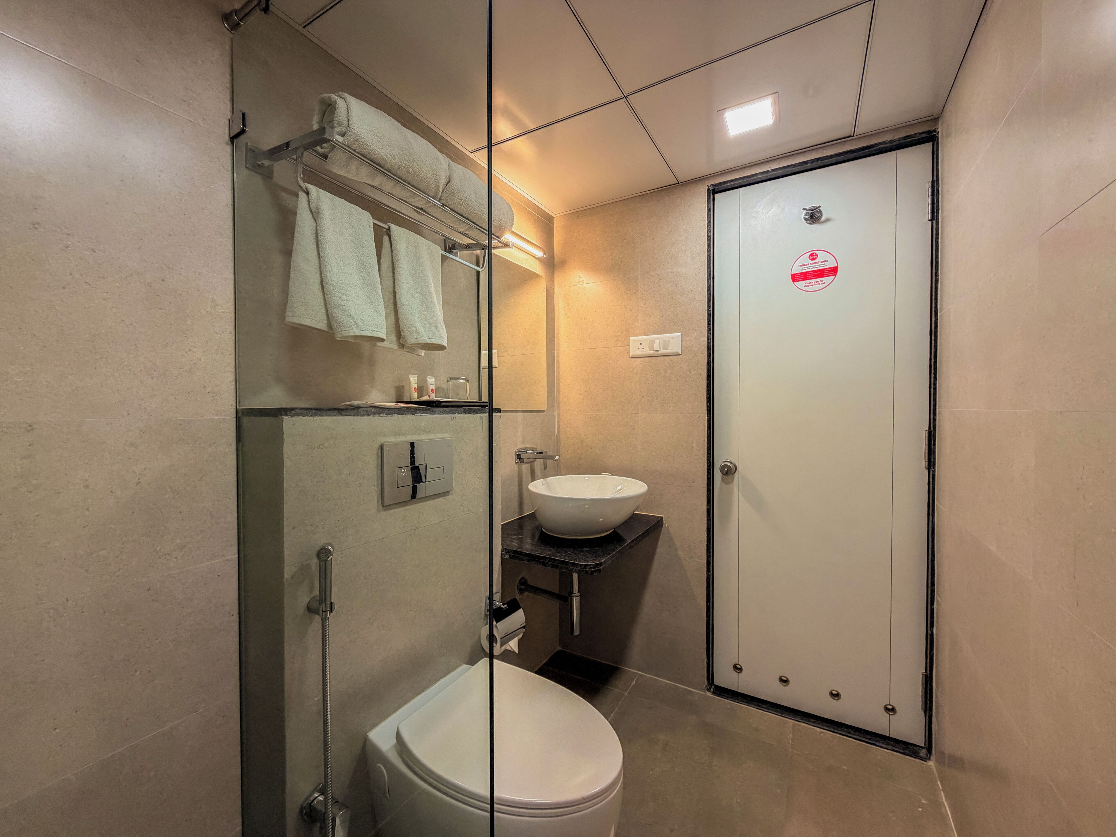 Un baño pequeño con inodoro, lavamanos y ducha.