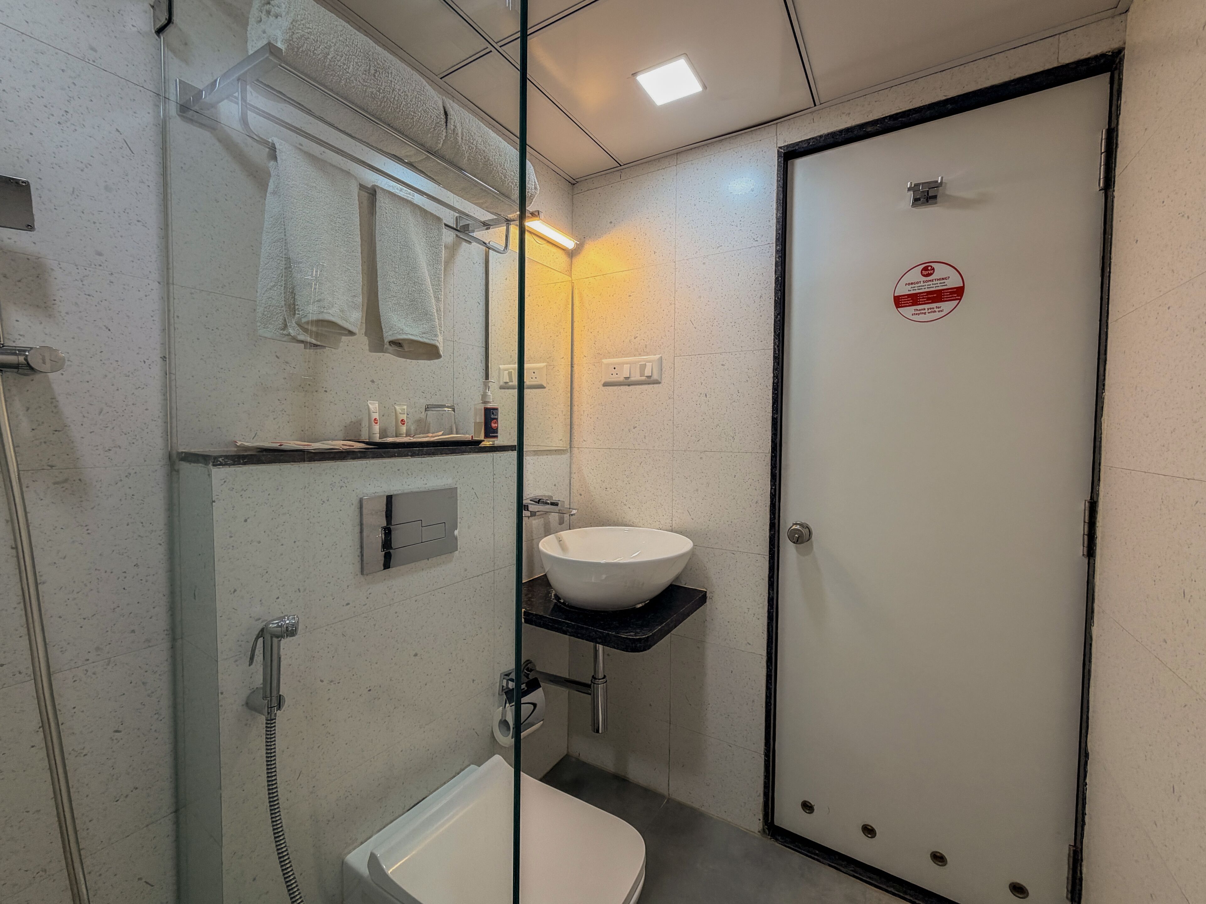 Ein modernes Badezimmer mit Duschkabine aus Glas, einem weißen Waschbecken und einer Toilette.