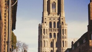 Una catedral histórica con una torre alta y ornamentada y ventanas de arco.
