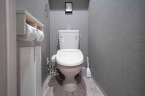 A modern bathroom with a toilet, a toilet paper holder, and a bidet. - COURT VILLA SAPPORO 102 (Sapporo)