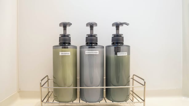 Three bottles of shampoo, conditioner, and body soap on a metal shelf. - COURT VILLA SAPPORO 403 (Sapporo)